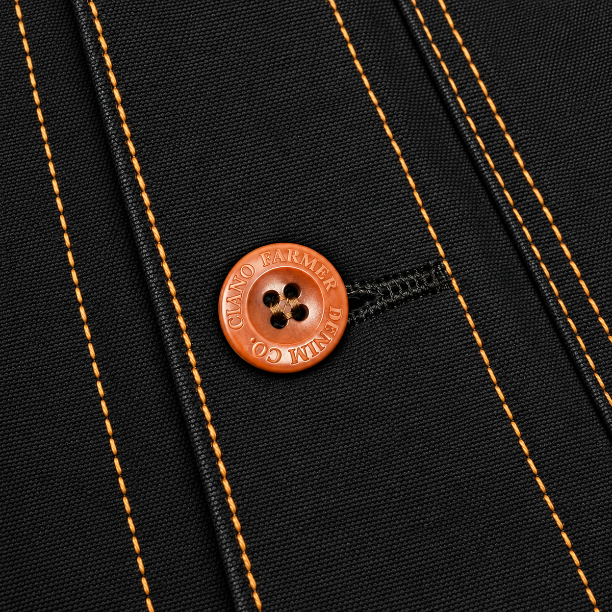 Close-up of a black textured fabric with bright orange contrast stitching and a round orange button embossed with 'BENJAMIN CO.'.