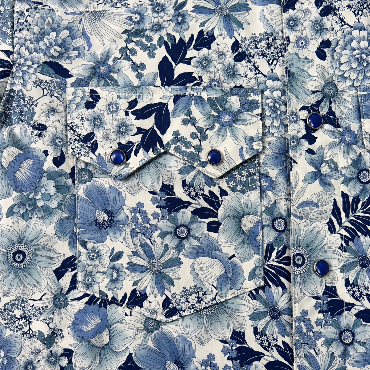 A close-up of a floral fabric with a pocket and snap-button flap, featuring blue and navy floral patterns on a cream background.