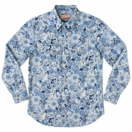 A long-sleeve button-up shirt with a dense blue and white floral and abstract pattern, laid flat against a white background.
